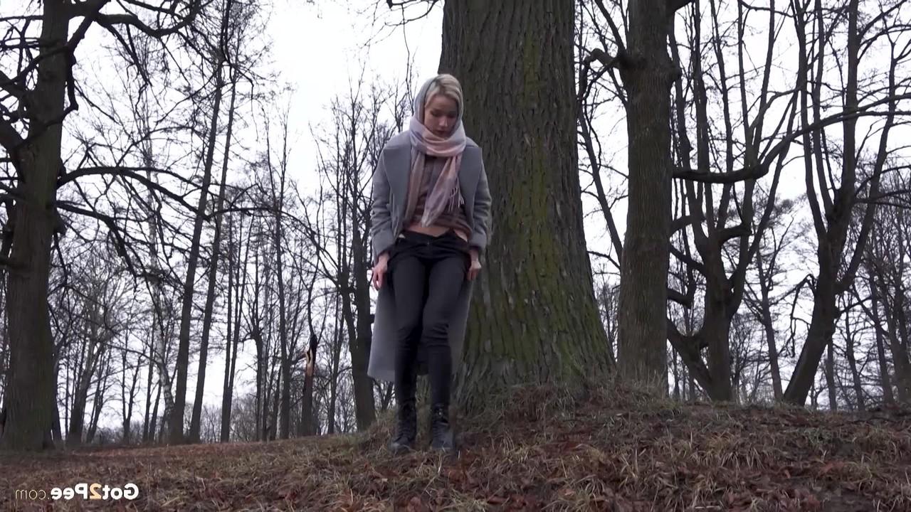 15P Das blonde Mädchen Masha pinkelt an einem kühlen Tag vor einem Baum