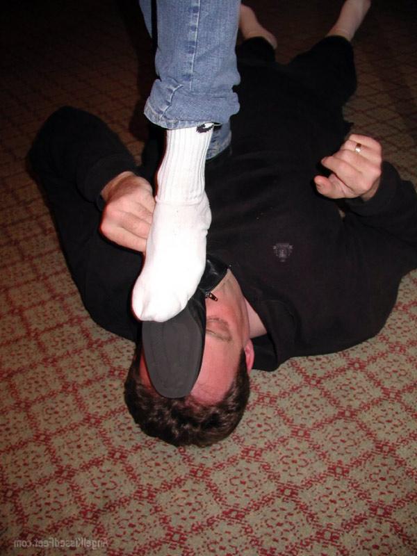15P Mulher totalmente vestida tira as botas enquanto pisoteia um homem de meias