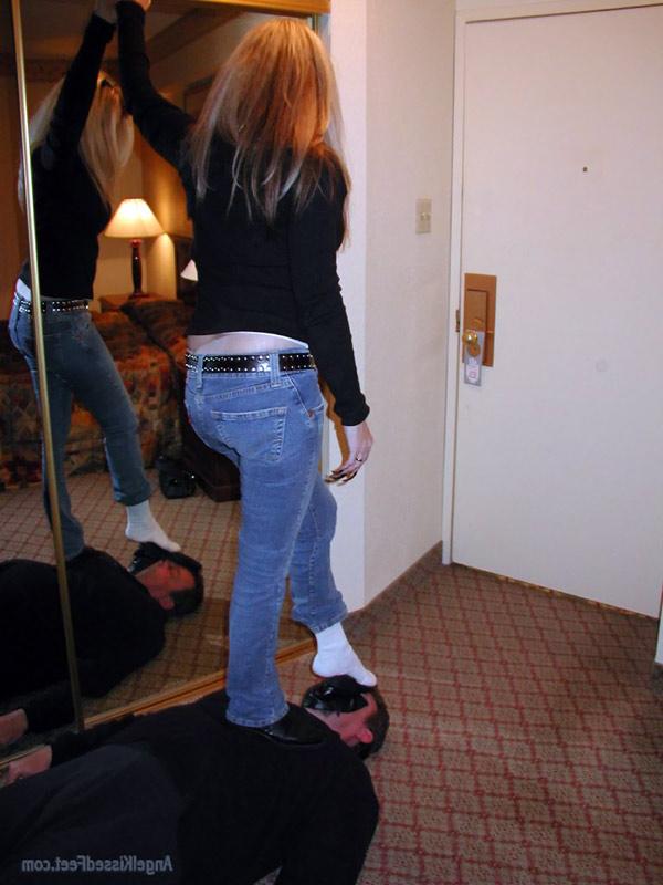15P Mulher totalmente vestida tira as botas enquanto pisoteia um homem de meias