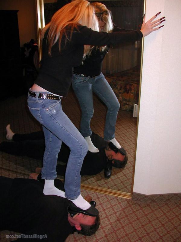 15P Mulher totalmente vestida tira as botas enquanto pisoteia um homem de meias