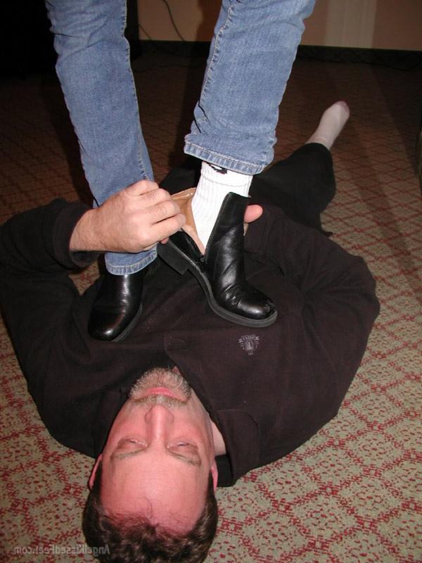 15P Mulher totalmente vestida tira as botas enquanto pisoteia um homem de meias