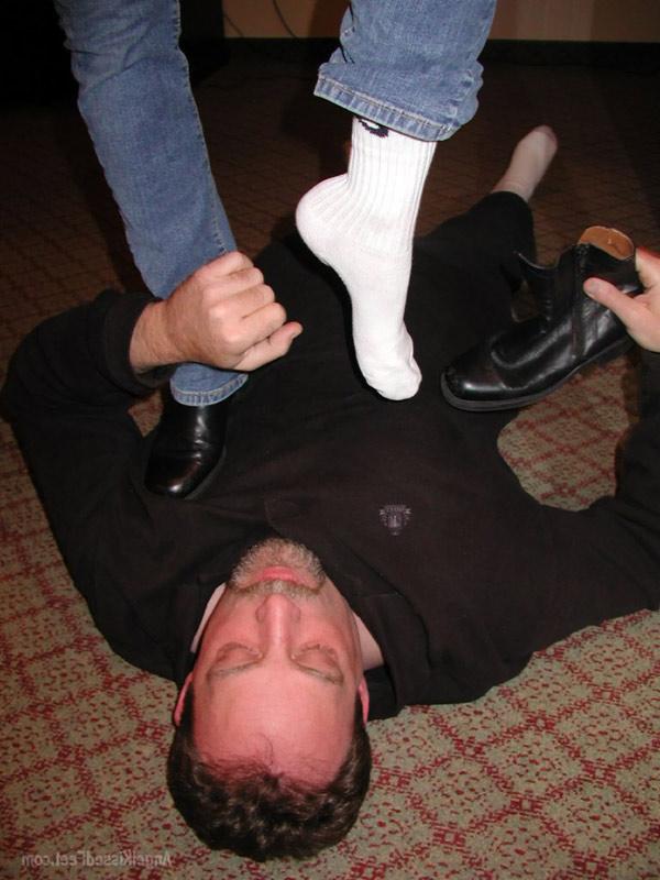 15P Mulher totalmente vestida tira as botas enquanto pisoteia um homem de meias