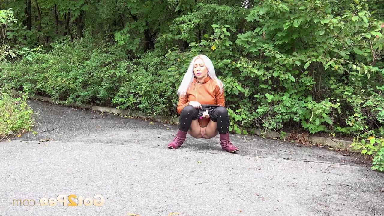 15P Platinum blonde squats for a piss on a paved road in the country