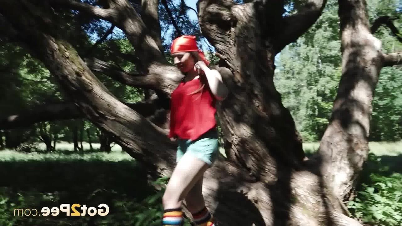 15P La jeune blonde Larisa fait pipi derrière un arbre en chaussettes multicolores