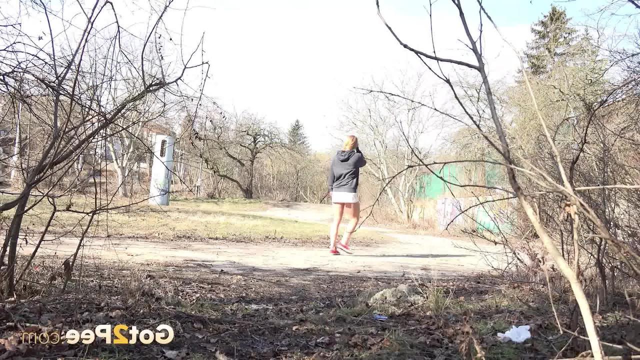 15P Chrissy Fox, une petite fille prise, pisse au milieu de buissons clairsemés.