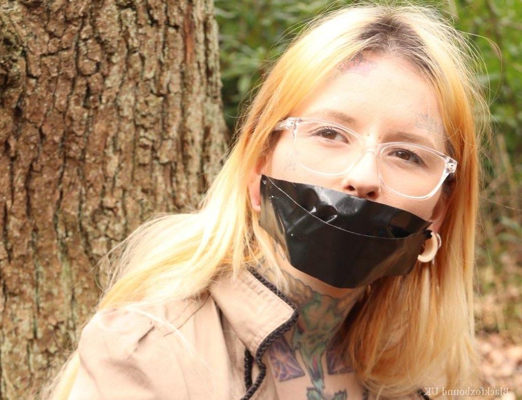 16P Nerdy girl is left gagged and rope bound against a tree in the forest