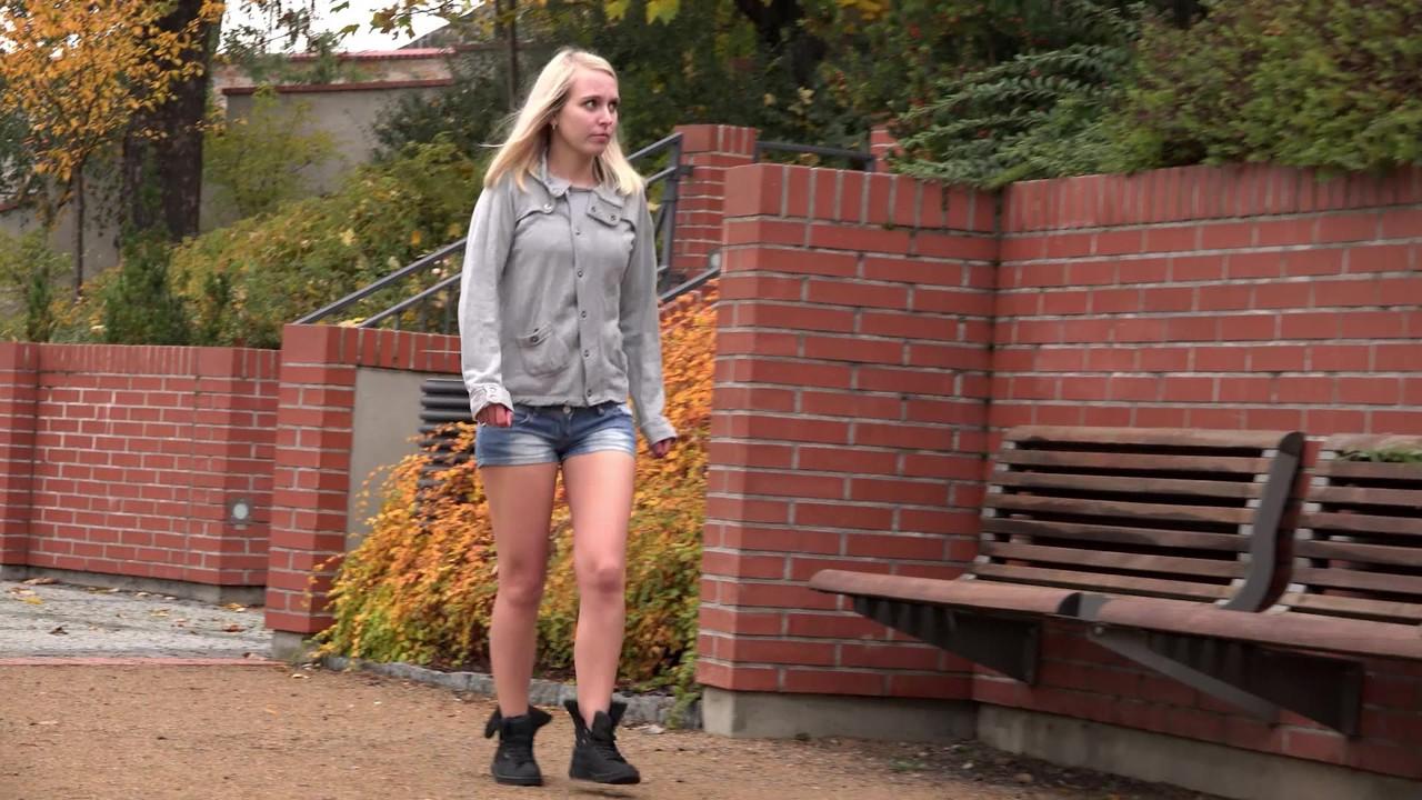 15P La blonde Debora enlève son short en jean pour faire pipi sur un banc public.