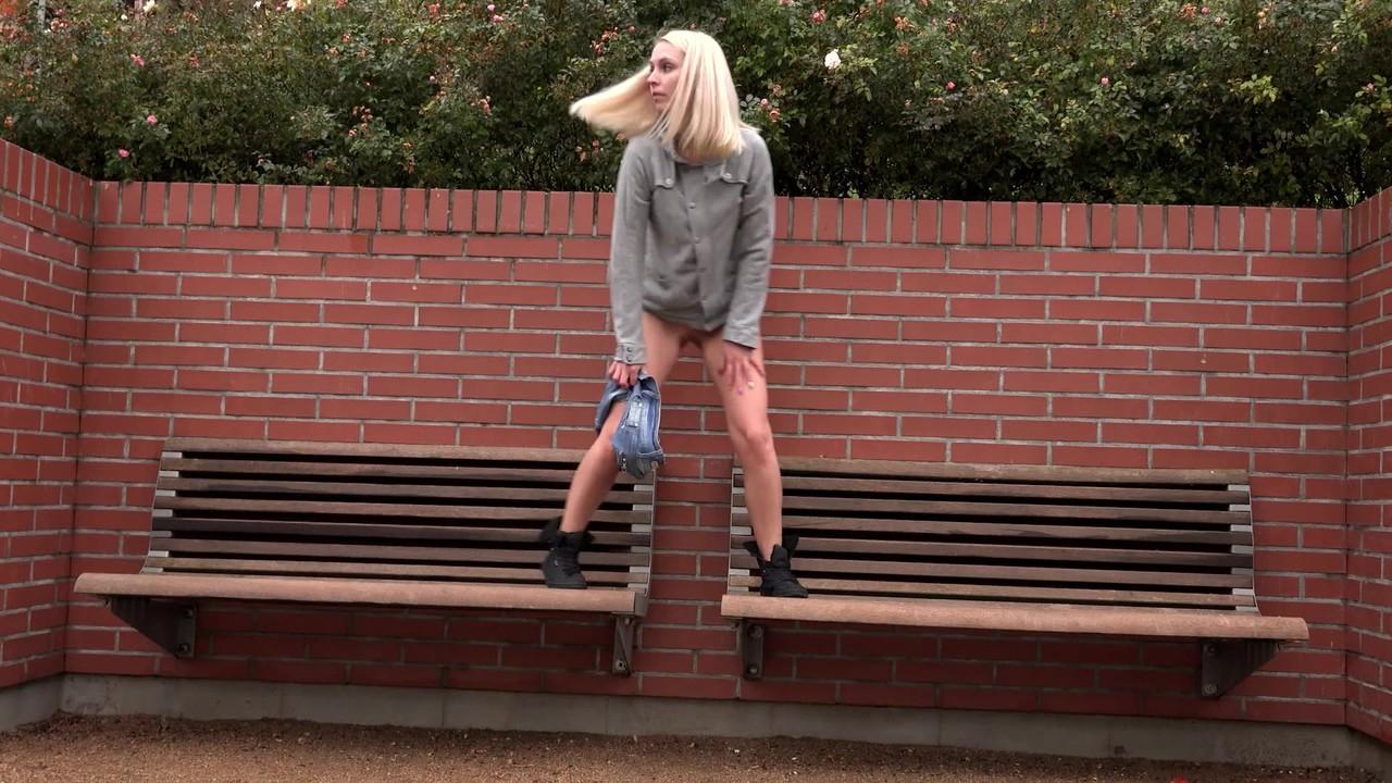 15P La blonde Debora enlève son short en jean pour faire pipi sur un banc public.
