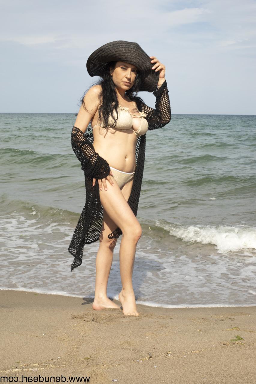 15P Dark-haired MILF poses on the beach and reveals her big juicy tits
