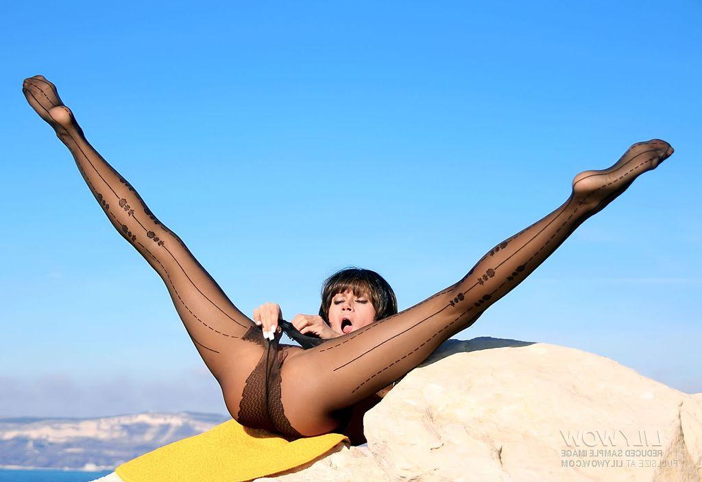 12P Brunette MILF models sexy pantyhose while wearing a sweater and heels