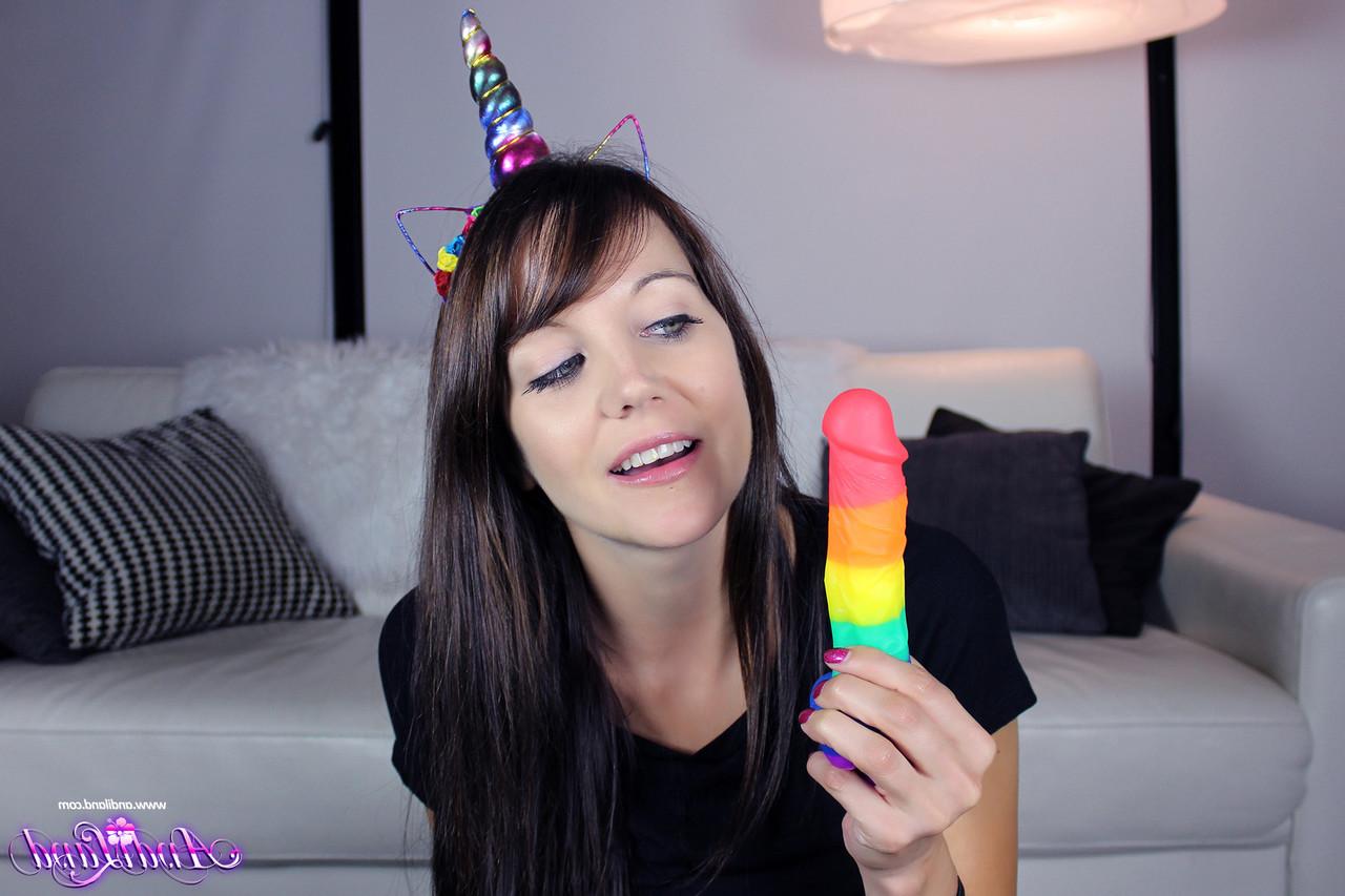 15P La jolie jeune fille Andi Land glisse un gode multicolore dans sa chatte rasée