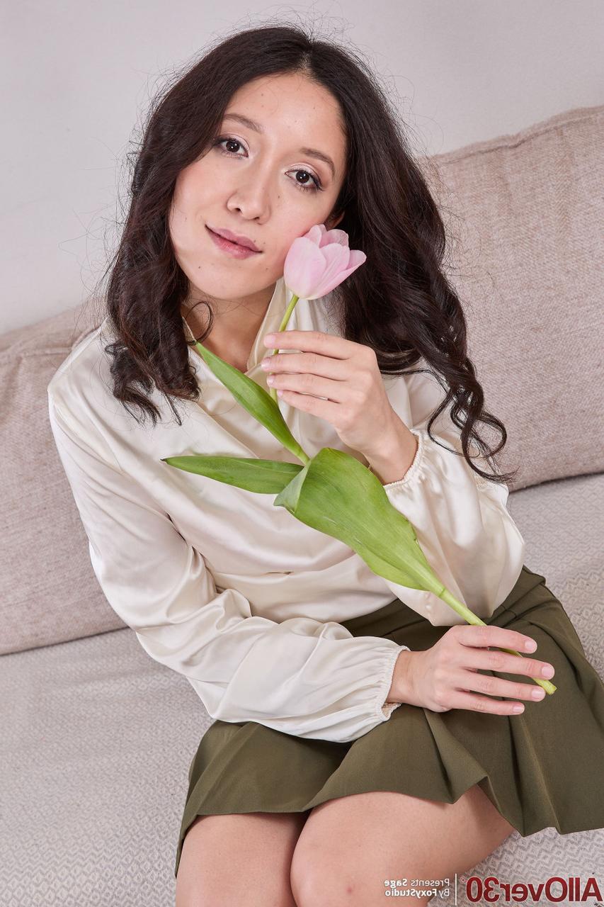 16P Brunette MILF Sage holds a fresh picked flower while getting totally naked