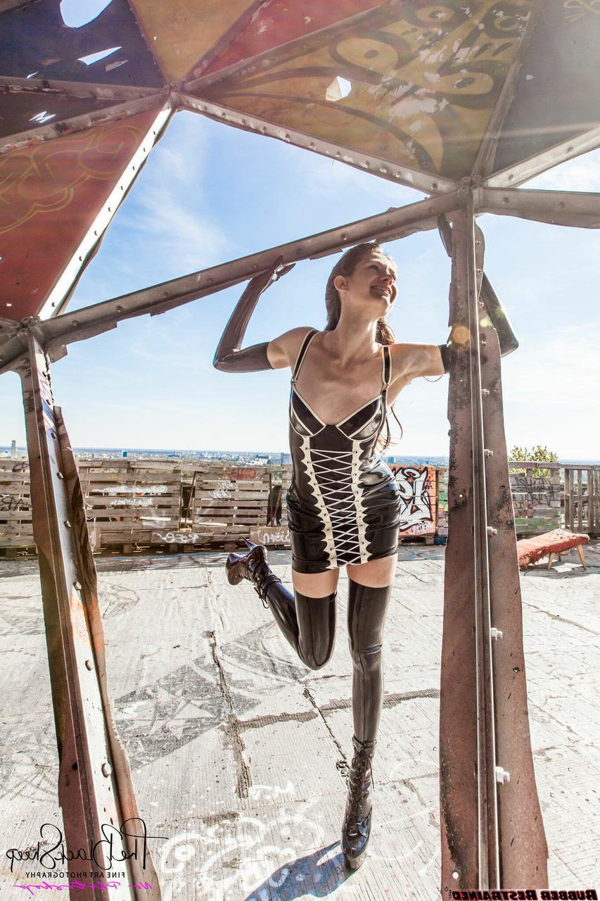 16P Fetish model Ropemarks wears latex clothing at an abandoned amusement park