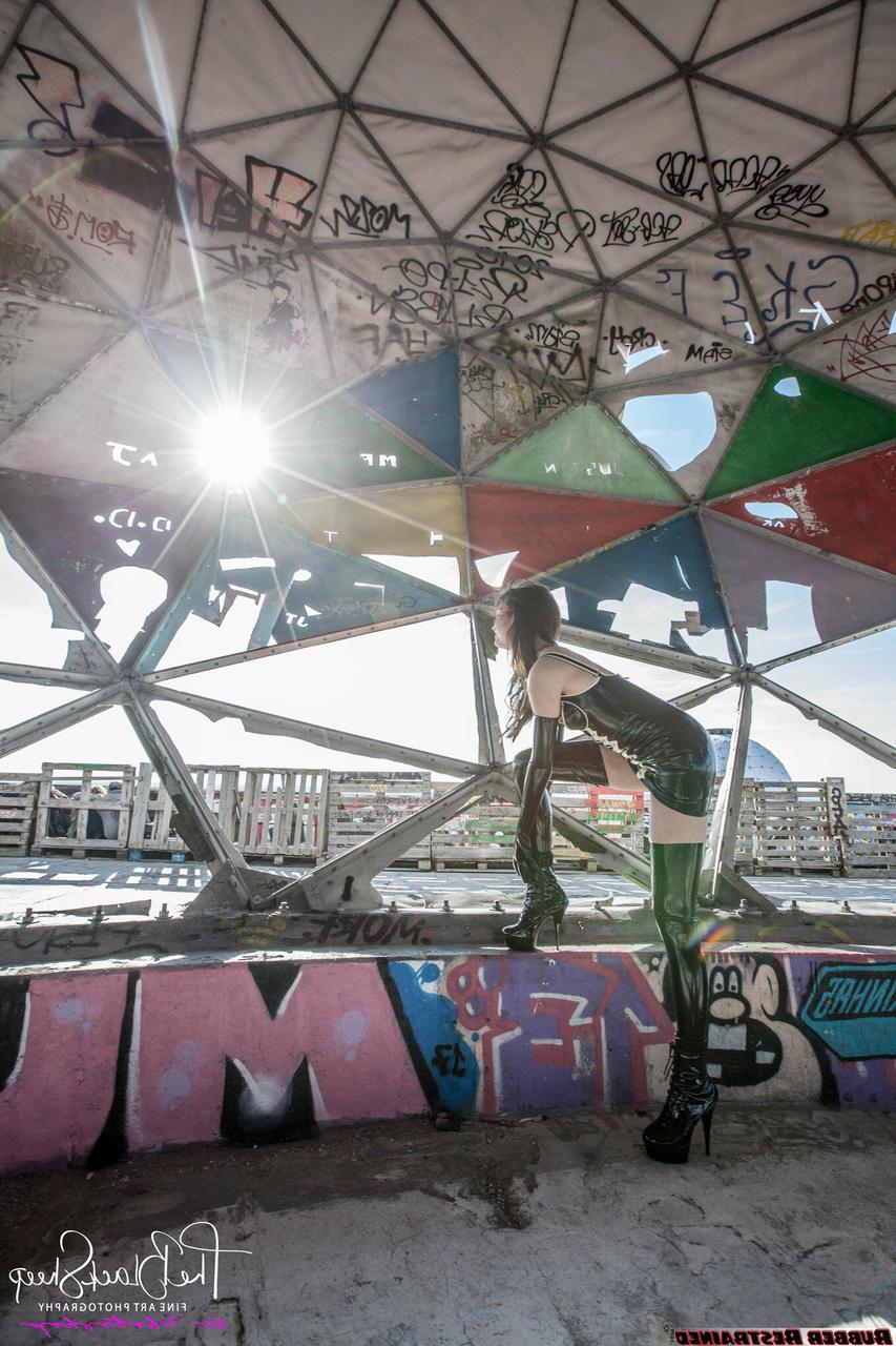 16P Fetish model Ropemarks wears latex clothing at an abandoned amusement park