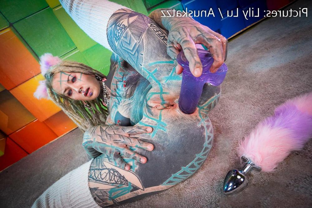 16P Anuskatzz, une fille fortement tatouée, joue avec son trou du cul tout en portant des dreadlocks.