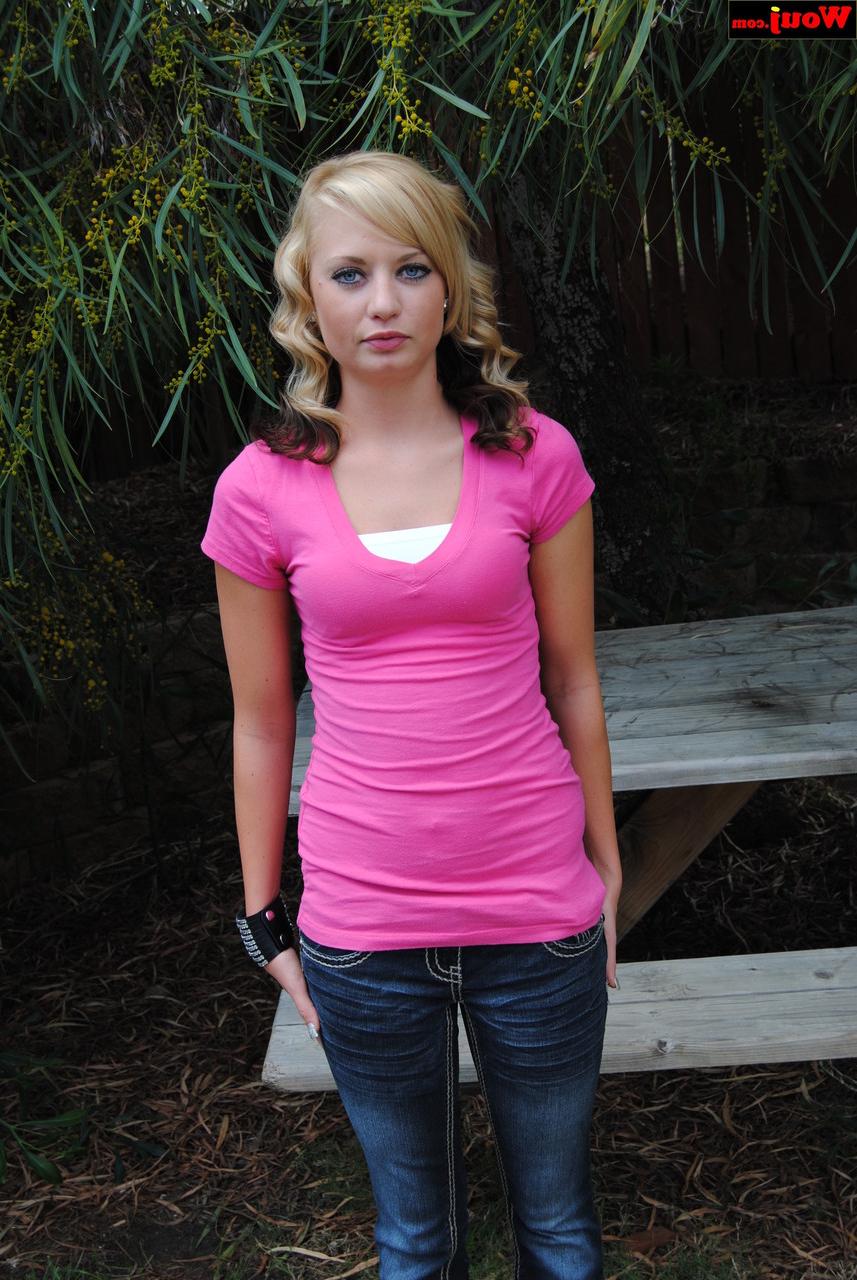 15P Gata amadora fofa posando com seu vestido rosa e jeans azul ao ar livre