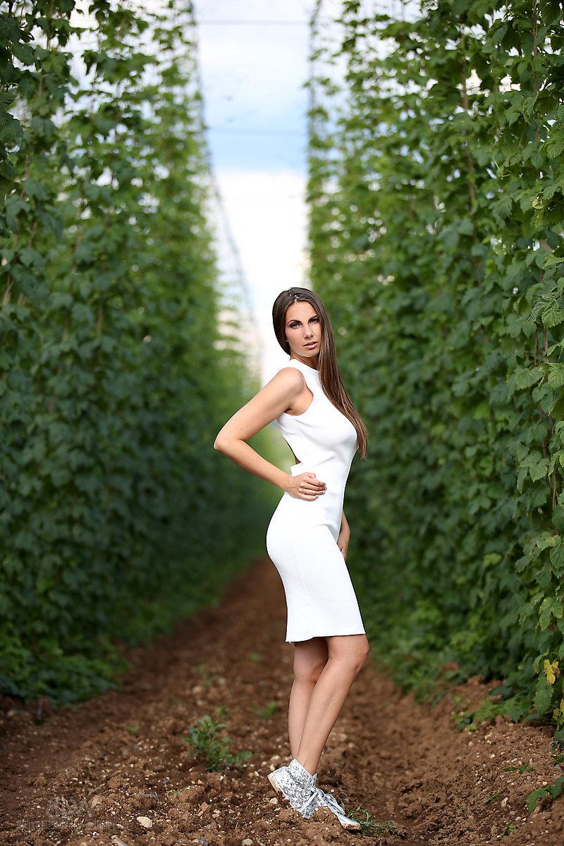 16P Busty beauty Connie Carter whips long hair about while naked in a crop field