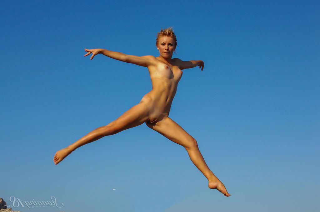 16P La jeune nue Tienette O affiche sa flexibilité lors d'une sortie à la plage.