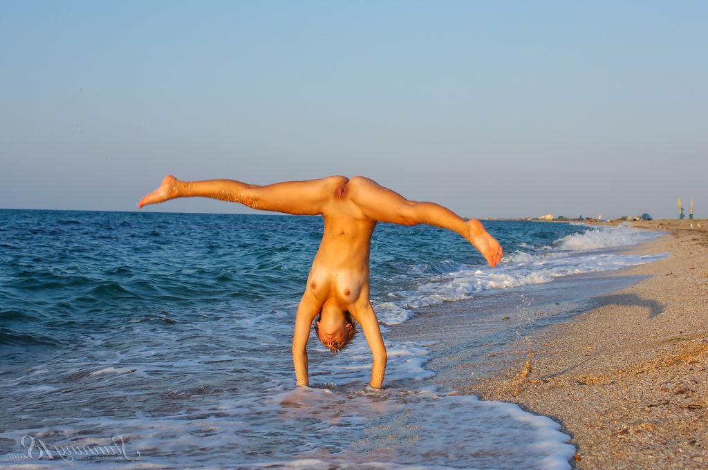 16P La jeune nue Tienette O affiche sa flexibilité lors d'une sortie à la plage.