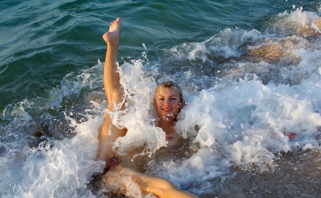 16P La jeune nue Tienette O affiche sa flexibilité lors d'une sortie à la plage.