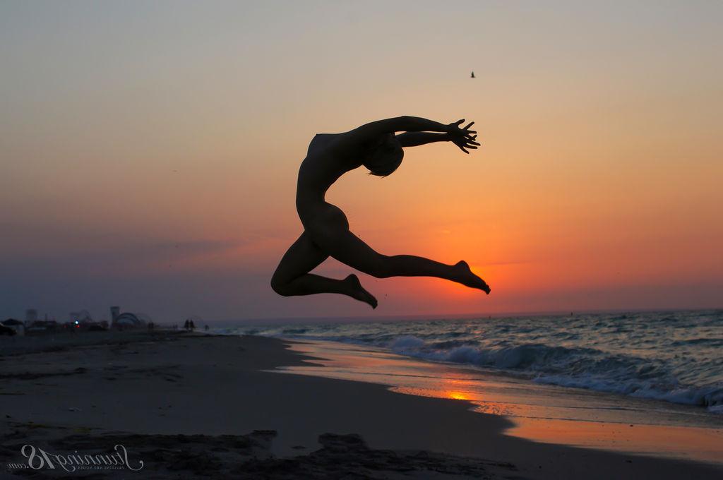 16P La jeune nue Tienette O affiche sa flexibilité lors d'une sortie à la plage.
