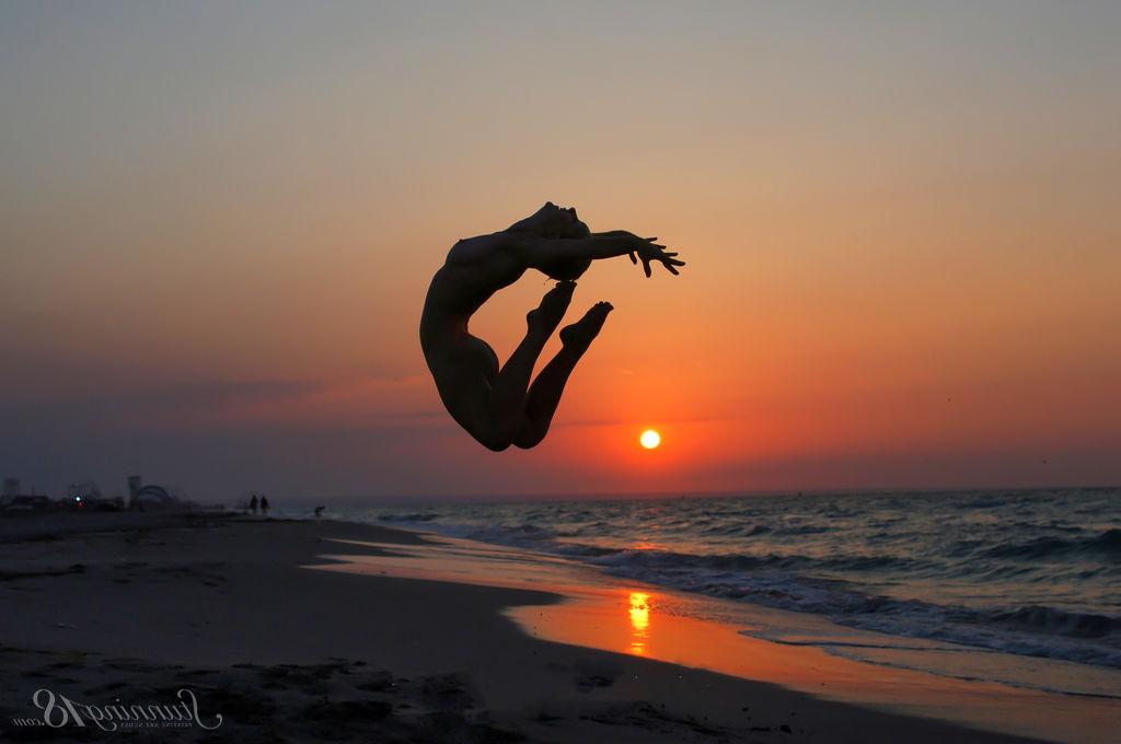 16P La jeune nue Tienette O affiche sa flexibilité lors d'une sortie à la plage.
