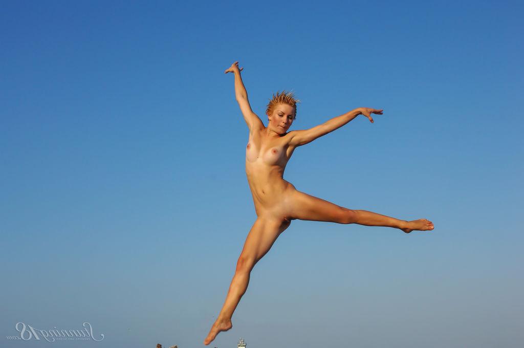 16P La jeune nue Tienette O affiche sa flexibilité lors d'une sortie à la plage.