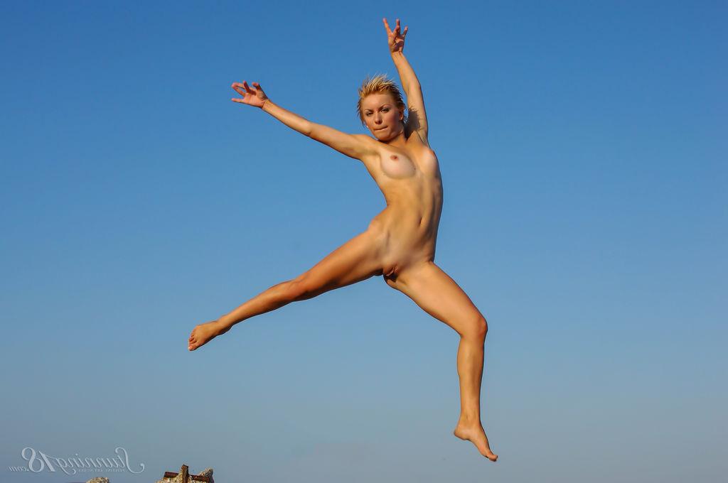 16P La jeune nue Tienette O affiche sa flexibilité lors d'une sortie à la plage.