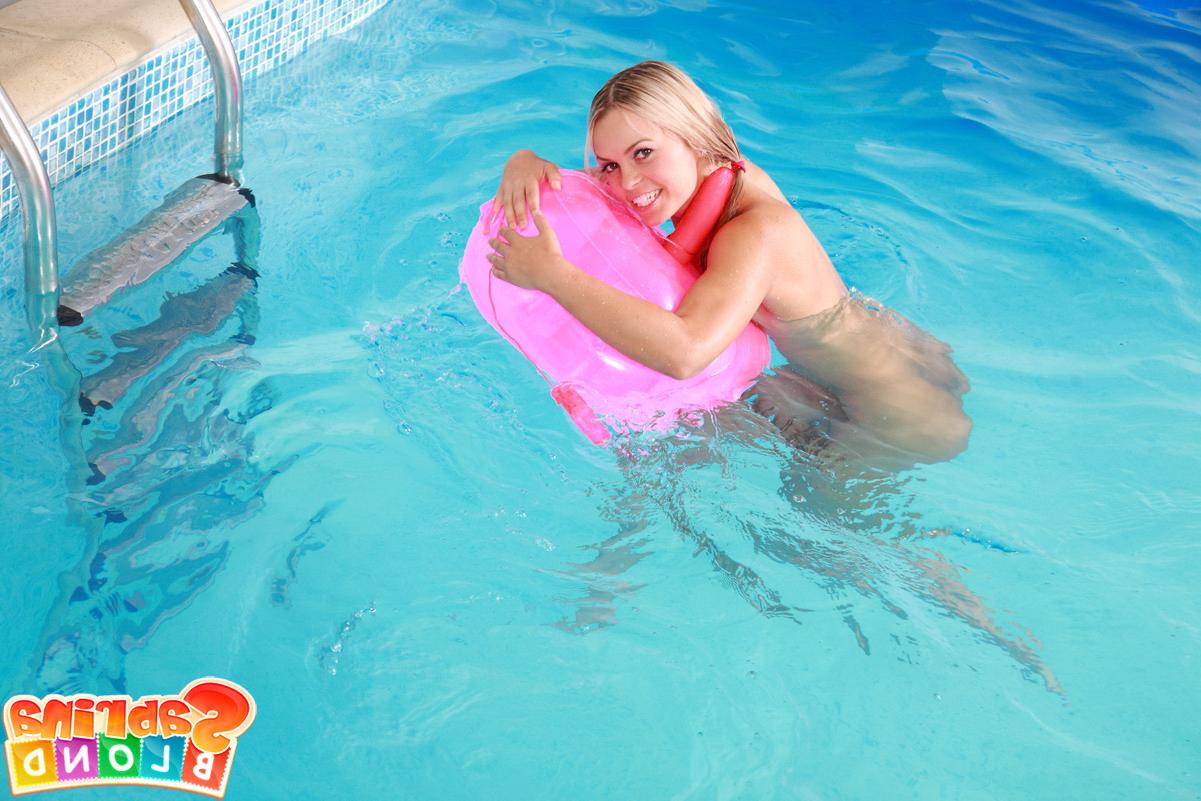 15P A adorável adolescente Sabrina Blond coloca um vibrador de almofada em sua vulva na piscina