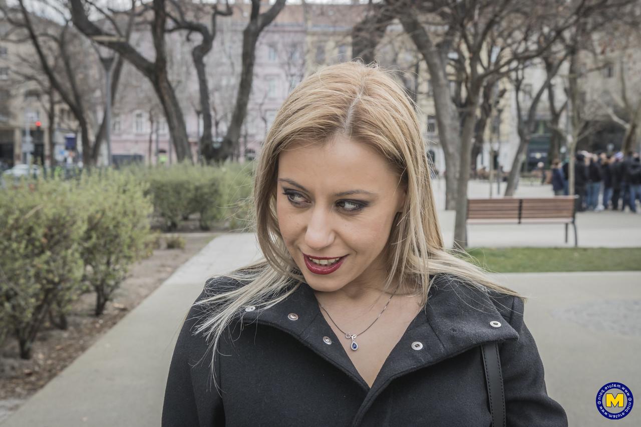 18P A sexy mãe europeia Nadina posa com seu casaco preto, botas e meias em público