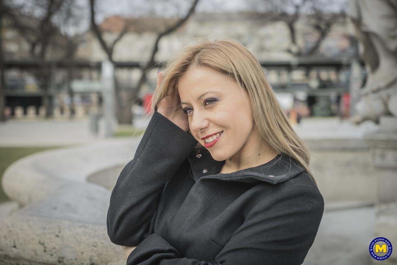 18P A sexy mãe europeia Nadina posa com seu casaco preto, botas e meias em público