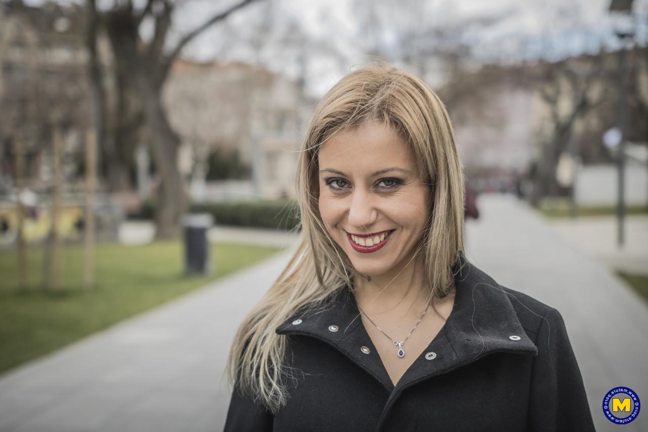 18P A sexy mãe europeia Nadina posa com seu casaco preto, botas e meias em público