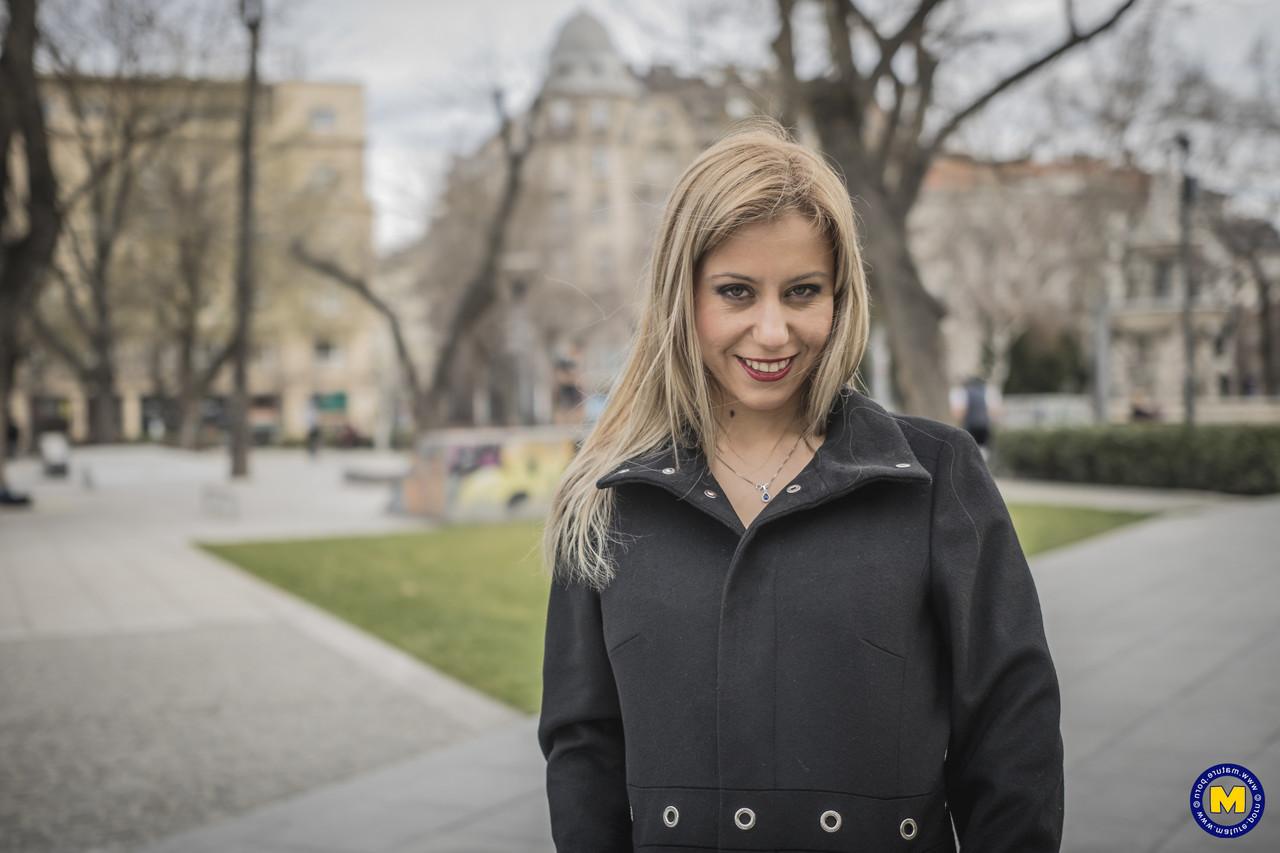 18P A sexy mãe europeia Nadina posa com seu casaco preto, botas e meias em público