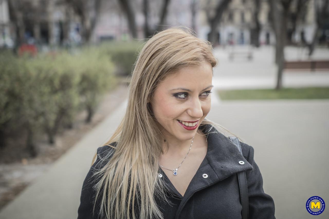 18P A sexy mãe europeia Nadina posa com seu casaco preto, botas e meias em público