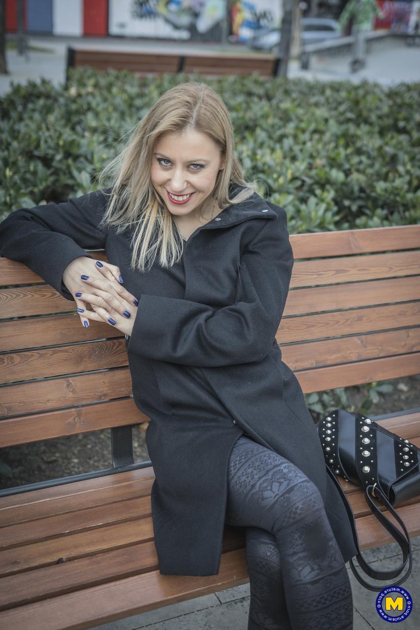 18P A sexy mãe europeia Nadina posa com seu casaco preto, botas e meias em público