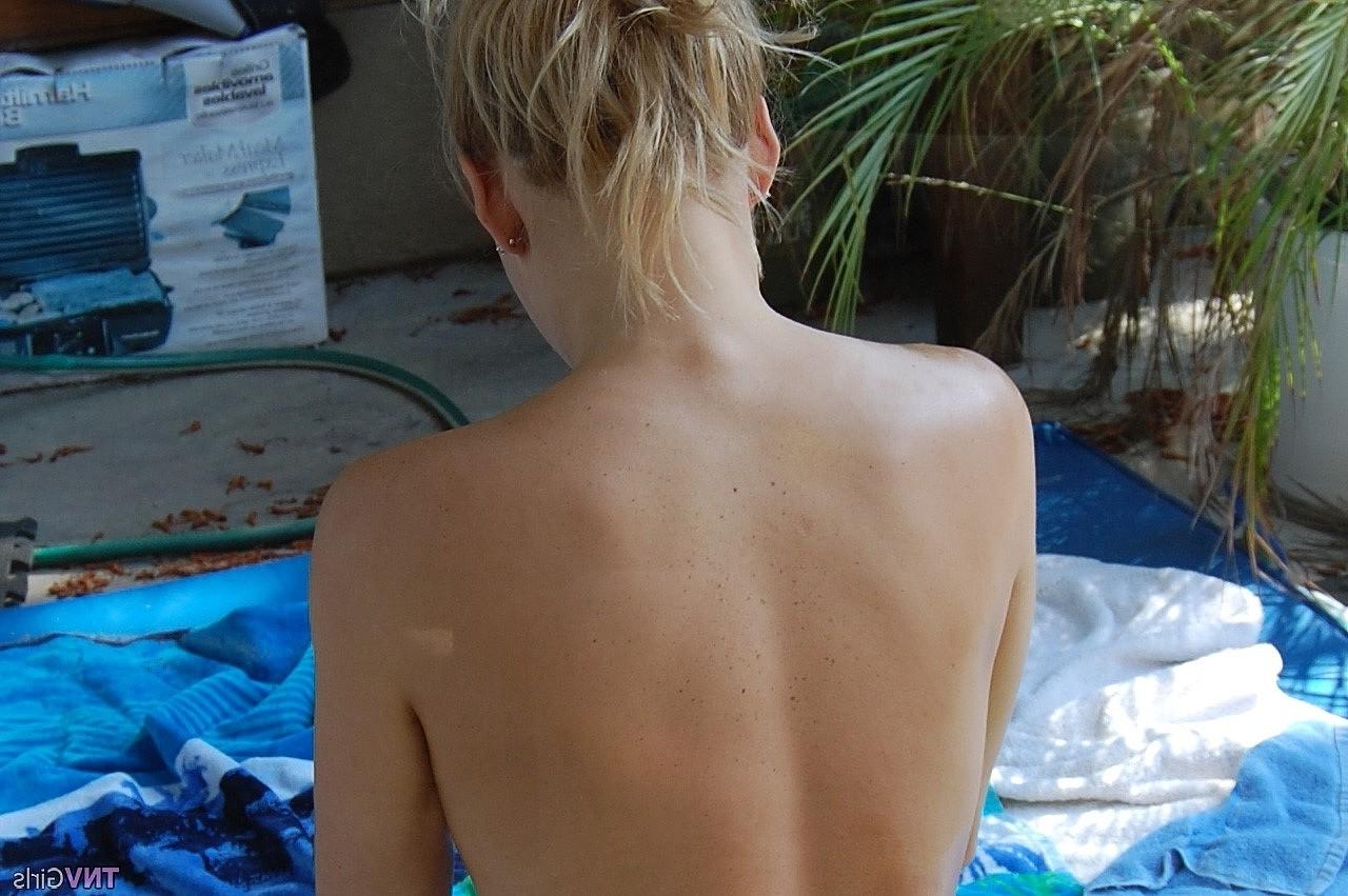 20P A adolescente de cabelos dourados Nikki lubrifica seu corpo nu sexy e posa em um solo