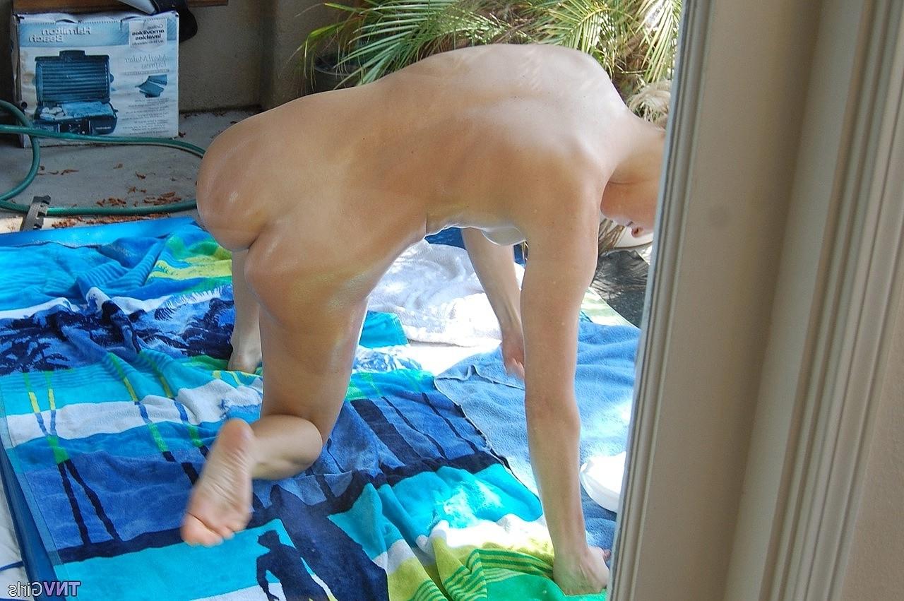 20P A adolescente de cabelos dourados Nikki lubrifica seu corpo nu sexy e posa em um solo