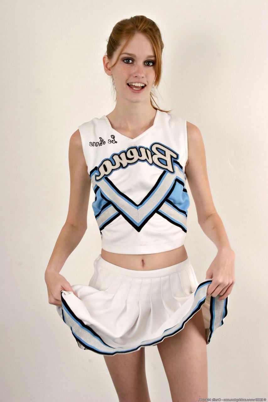 20P Die dünne Cheerleaderin Layla Exx enthüllt ihre kleinen Titten und ihre beschnittene Muschi