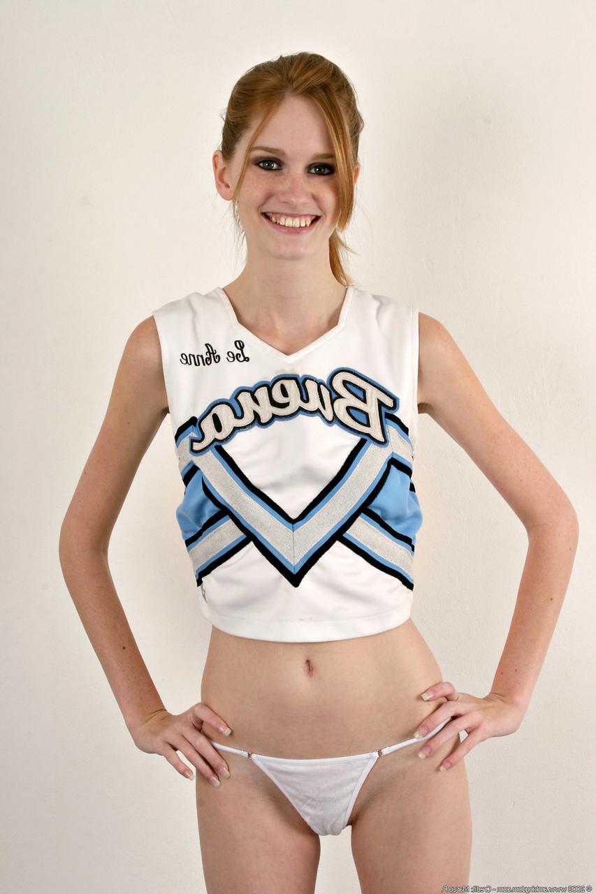 20P Die dünne Cheerleaderin Layla Exx enthüllt ihre kleinen Titten und ihre beschnittene Muschi