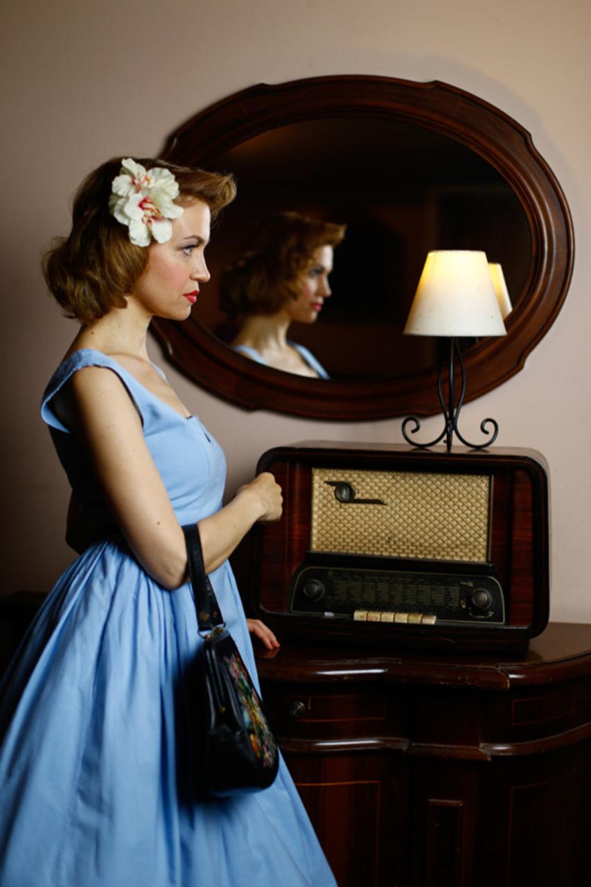 20P Nena angelical muestra su apariencia elegante con un vestido azul en una escena vintage