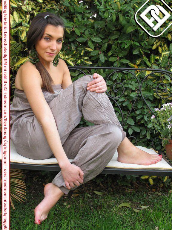 10P Une jolie brune affiche ses ongles fraîchement peints dans un jardin