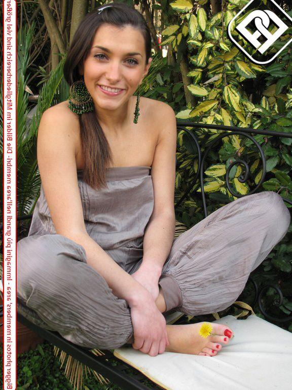 10P Une jolie brune affiche ses ongles fraîchement peints dans un jardin