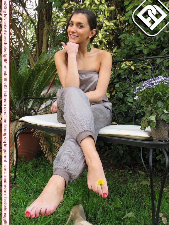 10P Une jolie brune affiche ses ongles fraîchement peints dans un jardin