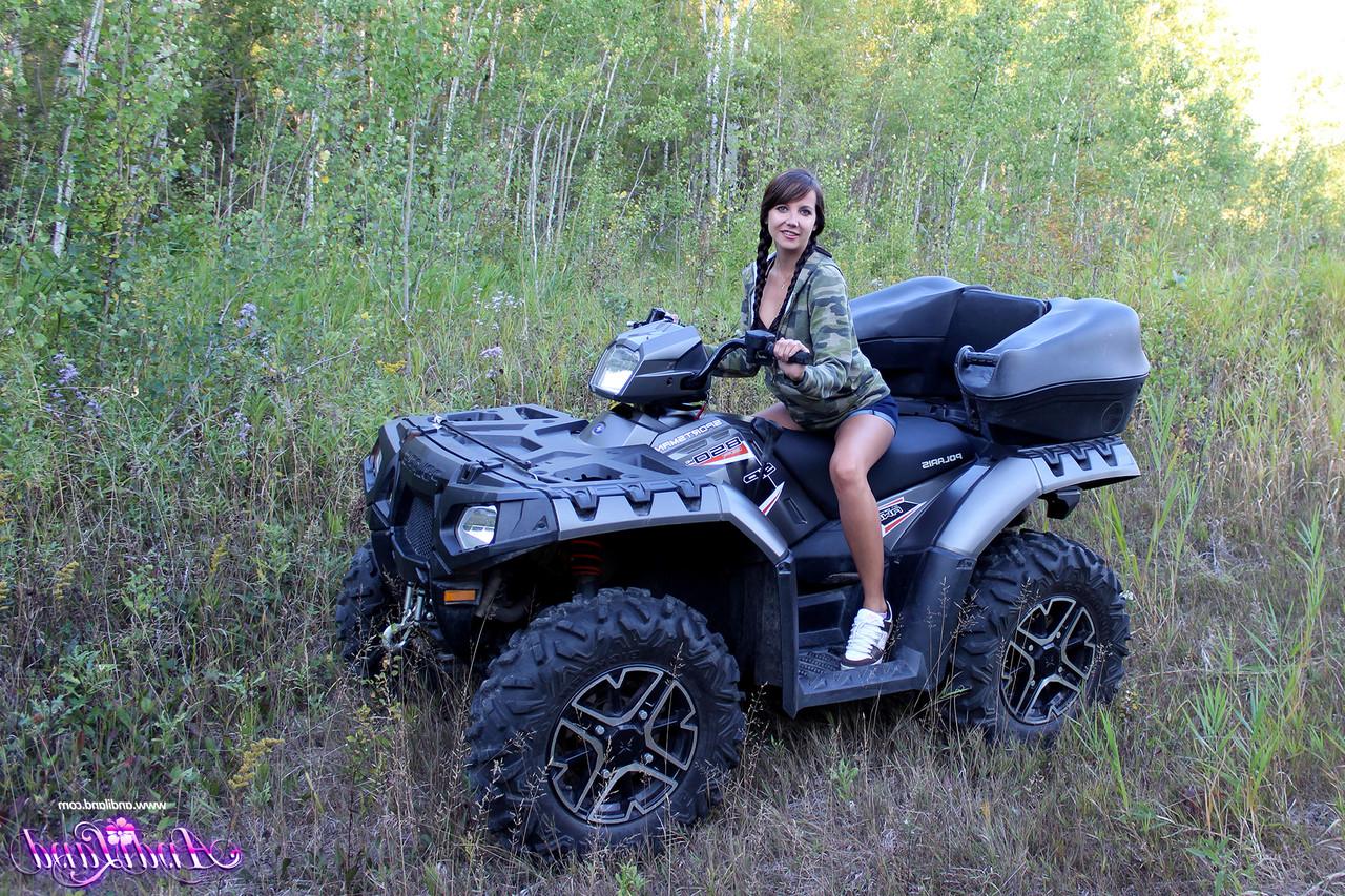 15P Young girl Andi Land shows her tiny tits and pussy on top of a four wheeler