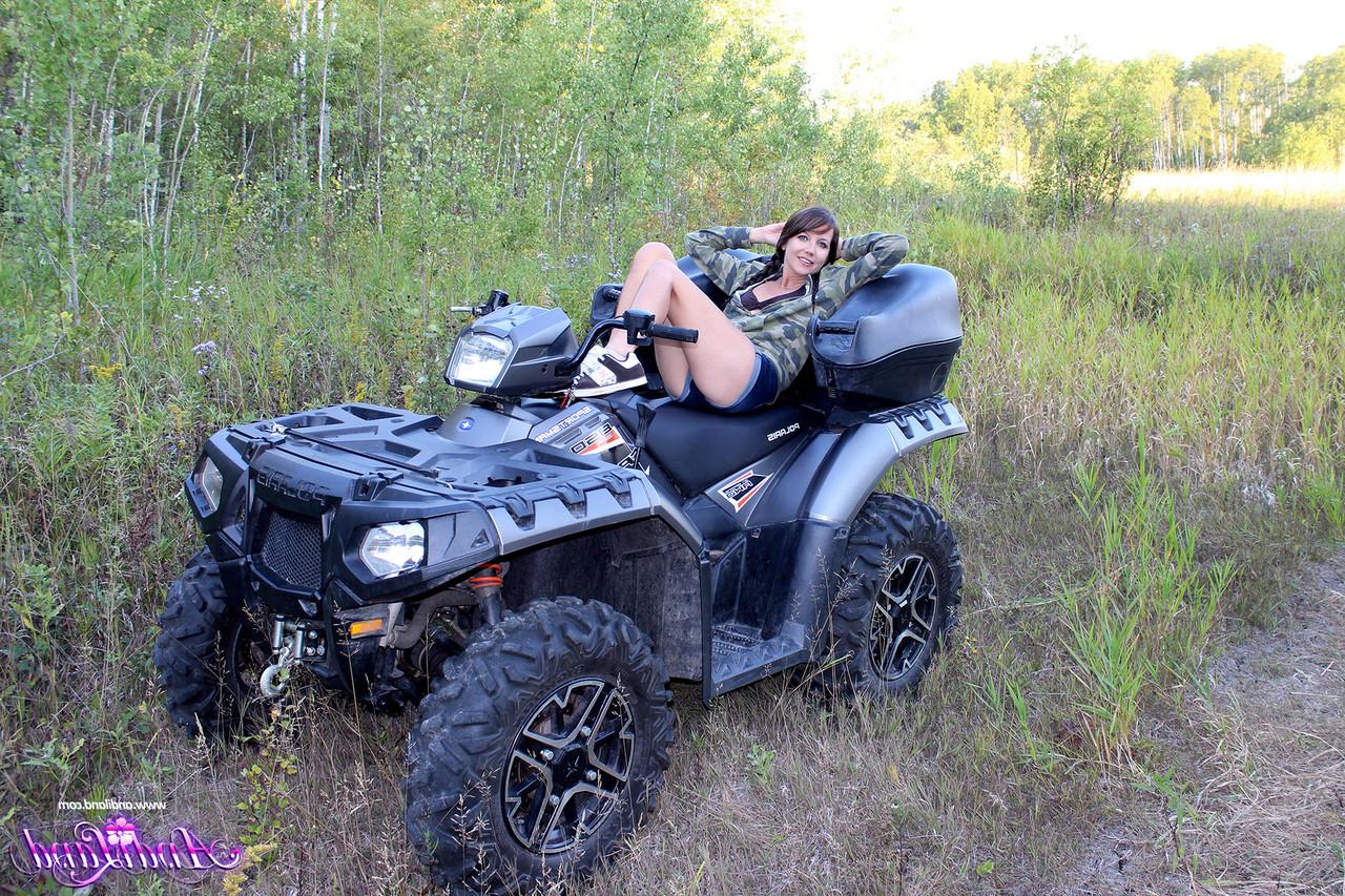 15P Young girl Andi Land shows her tiny tits and pussy on top of a four wheeler