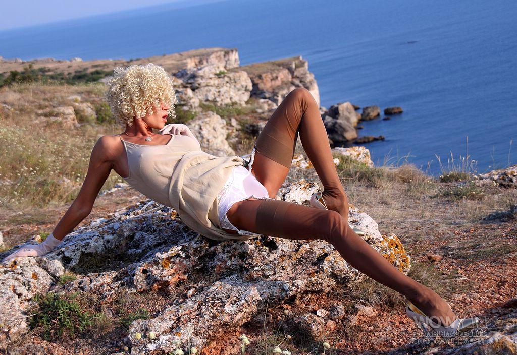 12P MILF sexy com cabelo loiro encaracolado puxa para baixo sua meia-calça vintage em um penhasco