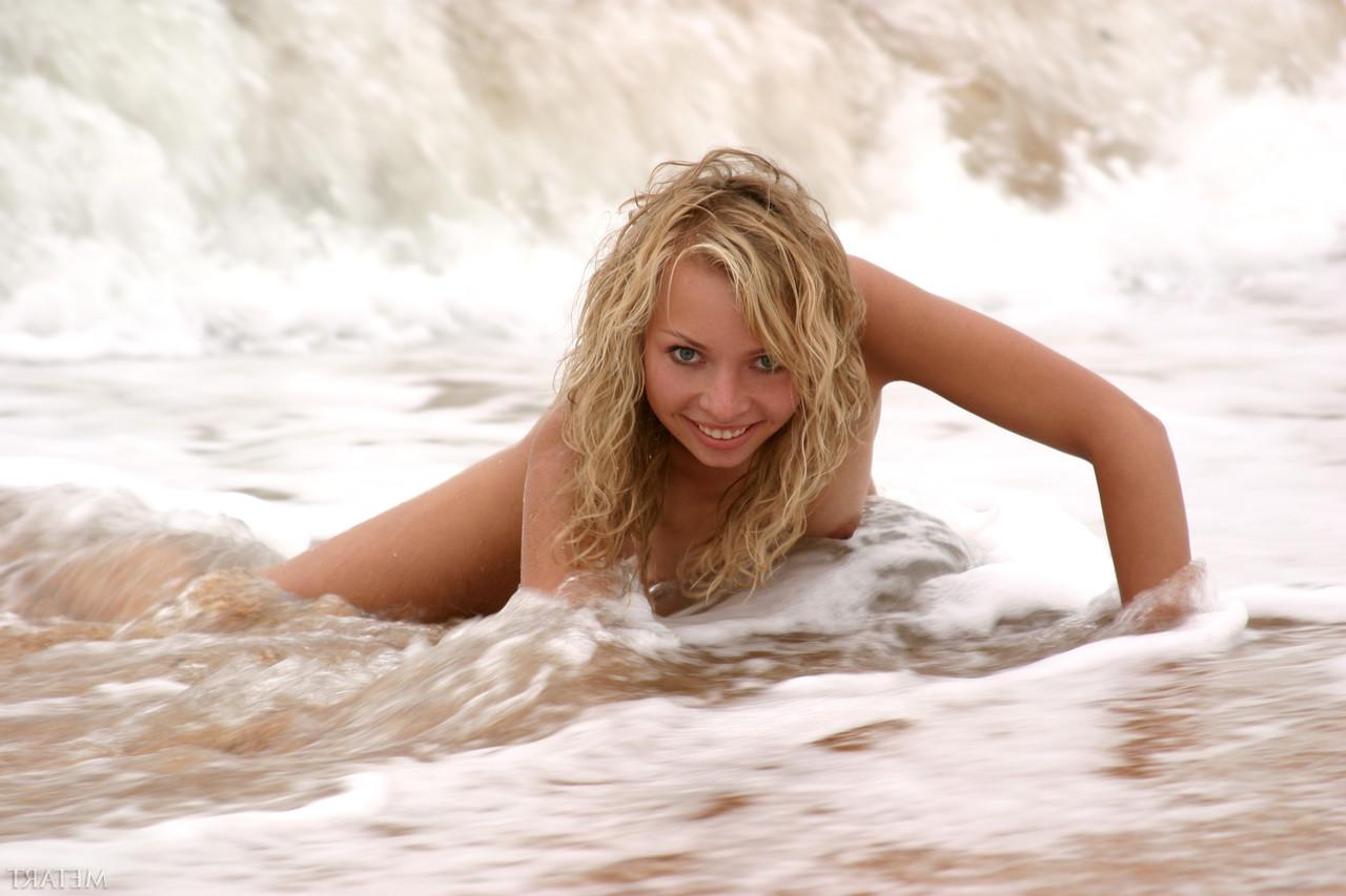 20P La jeune blonde Alena A taquine avec ses seins naturels et pose sur la plage.