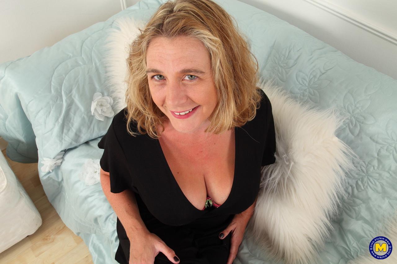 16P Older lady in black stockings and heels exposes her massive tits and pink twat