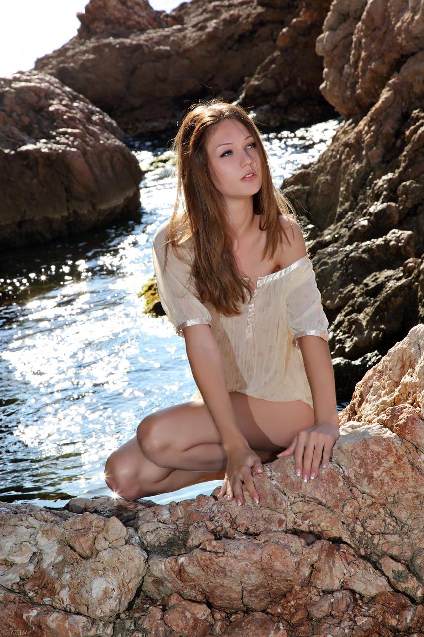 20P La magnifique jeune mannequin brune Lika C se déshabille dans l'eau de mer et pose nue.