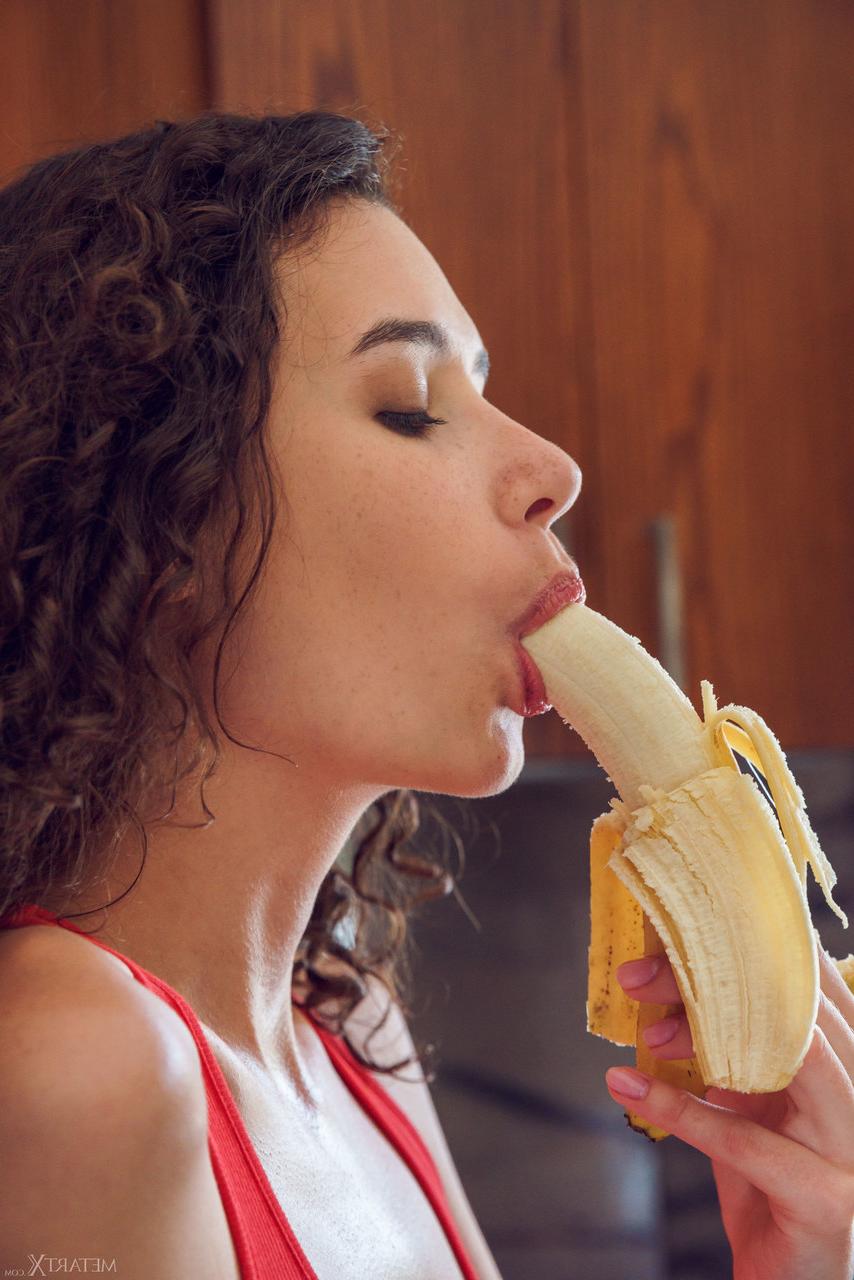 20P Brunette teen Cristin fondles her juggs and stirps while sucking on a banana